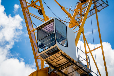 A large yellow crane stands out against a bright blue skyの写真素材