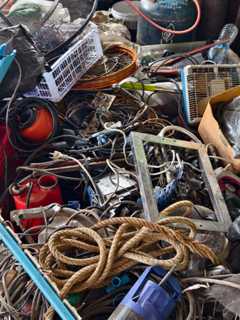 A pile of garbage with a bucket, rope, bottles, and other items at a landfill