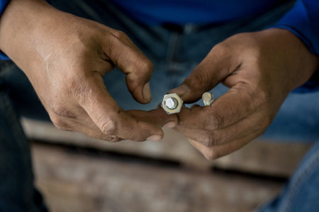A builder works with screws and nuts on a wooden pallet