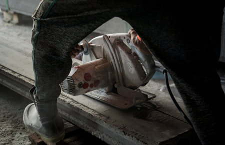 A builder using a circular saw to cut a large concrete piece