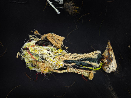 There is a pile of tightly wound rope and colorful yarn on a black surfaceの写真素材