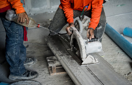 A builder using a circular saw to cut a large concrete piece