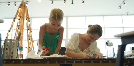 Mother and her daughter paint cookies