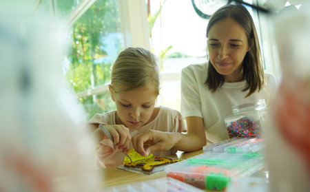 Teacher in workshop teched two girls how to assemble a mosaicの写真素材