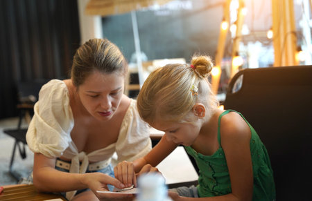 Mother and her daughter paint cookiesの写真素材
