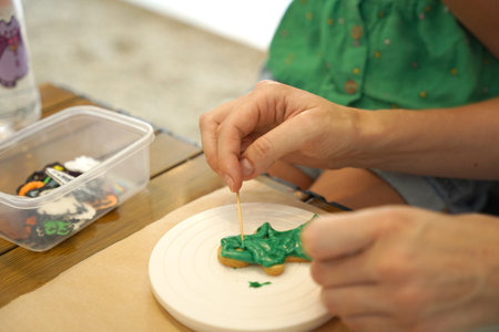Mother and her daughter paint Halloween cookiesの写真素材