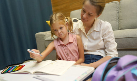 A mother supports her daughter with homework