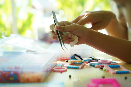 Teacher in workshop taught two girls how to assemble a mosaic