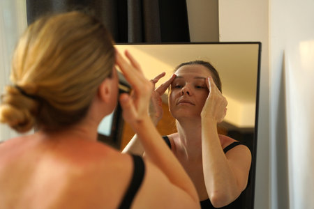 A young woman is enjoying a wonderfully serene morning in her bedroom.の写真素材