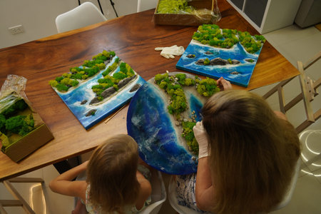 A mother and her daughter craft vibrant natural landscapes