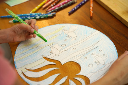 A mother and her young daughter engage in a colorful painting activityの写真素材