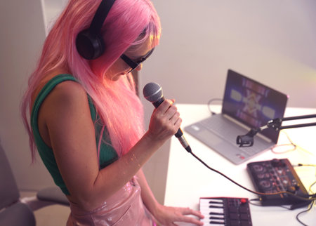 Beautiful young singer and musician broadcast from her home studioの写真素材