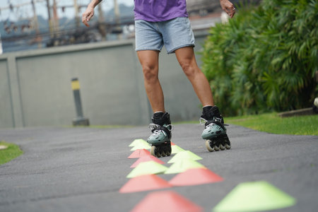 A woman is rollerblading gracefully on a road located in a park