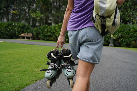 A woman is rollerblading gracefully on a road located in a parkの写真素材