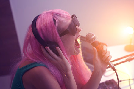 Beautiful young singer and musician broadcast from her home studioの写真素材