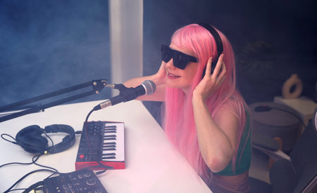 Beautiful young singer and musician broadcast from her home studioの写真素材