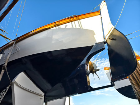 A boat's hull and propeller are visible against a bright blue sky