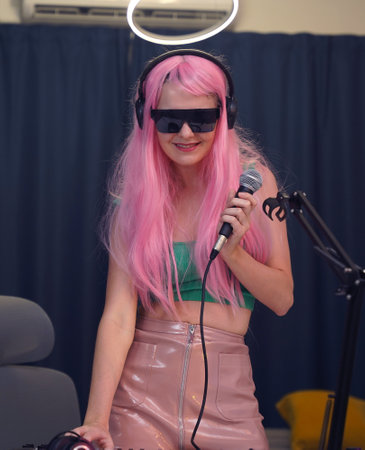 Beautiful young singer and musician broadcast from her home studioの写真素材