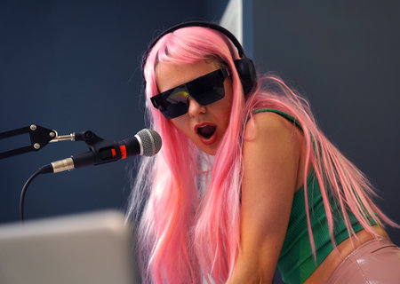 Beautiful young singer and musician broadcast from her home studioの写真素材