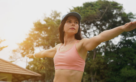 A young woman is joyfully practice a yoga mat in a beautiful parkの写真素材