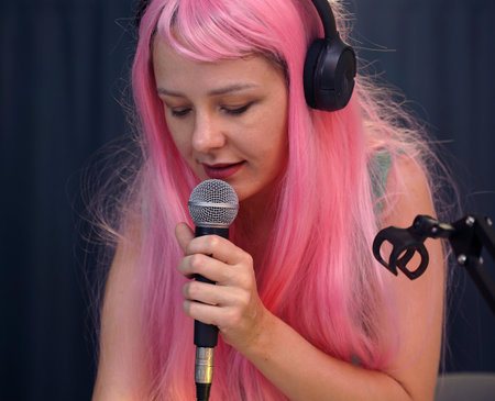 Beautiful young singer and musician broadcast from her home studioの写真素材