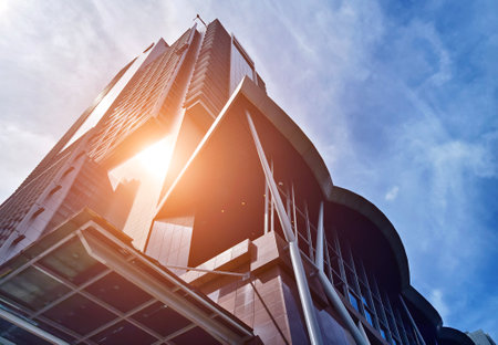 A modern tall building that features a significant amount of glassの写真素材