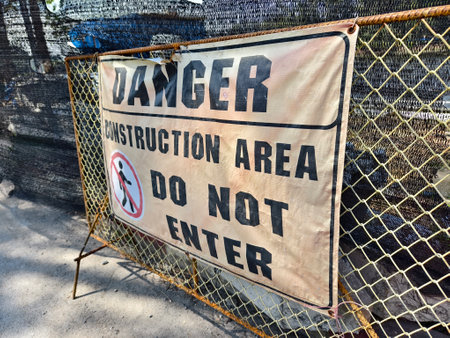 There is a noticeable sign warning of danger in front of the entrance to the construction siteの写真素材