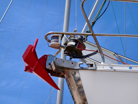A bright red anchor is securely attached to the side of a sailing boatの写真素材