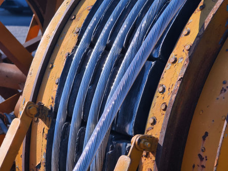 A large wooden spool of high-voltage electric wires is located on the road