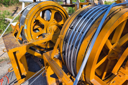 A large wooden spool of high-voltage electric wires is located on the road