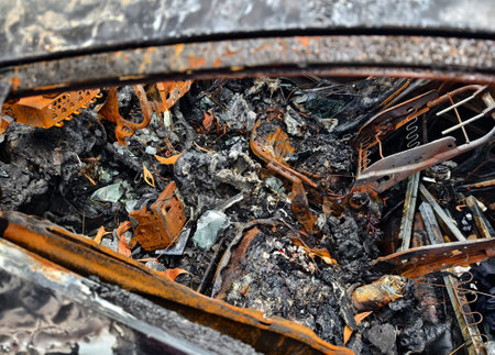 Charred remnants of a vehicle interior left behind after a devastating fire incidentの写真素材