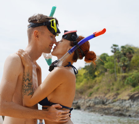 A man and woman wear goggles and snorkels before divingの写真素材