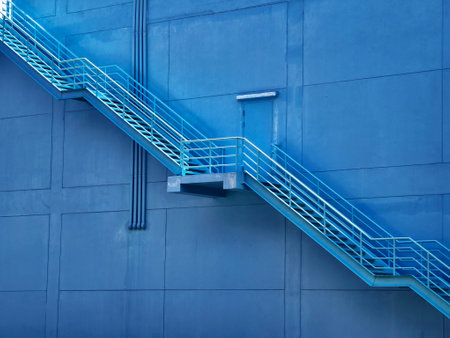 A set of stairs ascending a large blue wallの写真素材