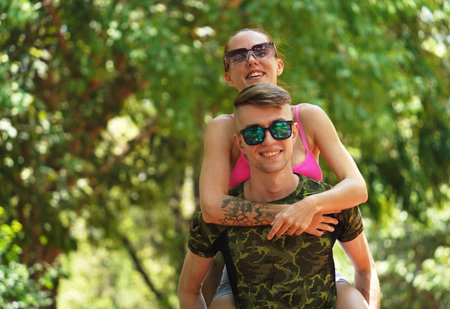 A man and a woman wearing stylish sunglasses in a park