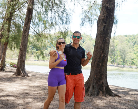 A man and a young woman are playing badminton together in a parkの写真素材