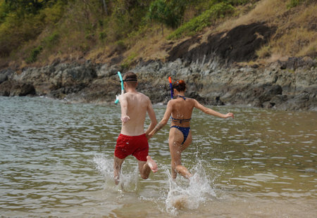 A man and woman wear goggles and snorkels enjoying the waterの写真素材