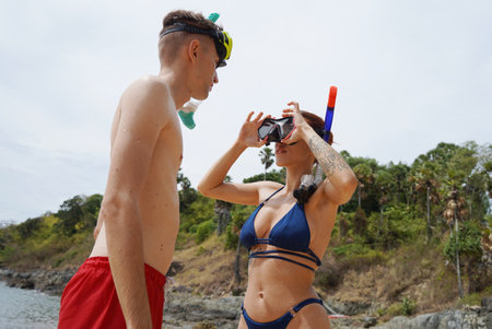A man and woman wear goggles and snorkels before divingの写真素材