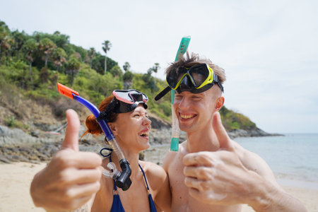A man and woman wear goggles and snorkels before divingの写真素材
