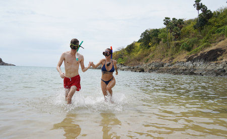 A man and woman wear goggles and snorkels enjoying the waterの写真素材