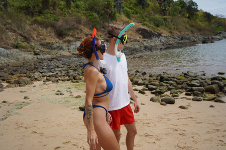 A man and woman wear goggles and snorkels before divingの写真素材