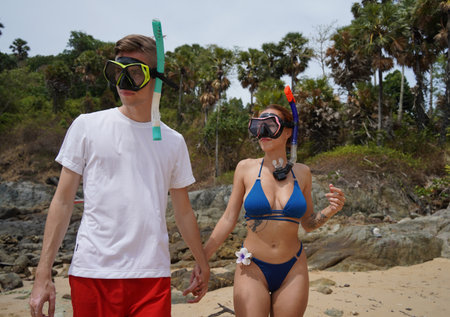 A man and woman wear goggles and snorkels before divingの写真素材