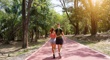 Man and woman walking on a path in a beautiful parkの写真素材