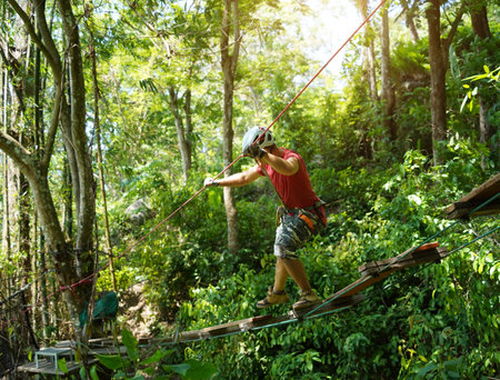 A man is walking across a challenging ropes course in the extreme park