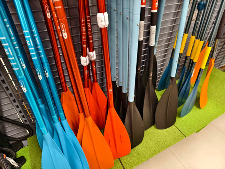 A collection of oars is lined up neatly in a row for use