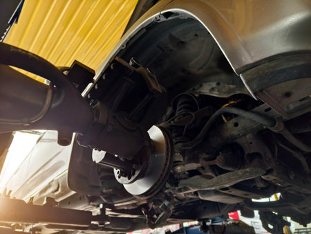 A car is currently being repaired by a skilled mechanic in a garageの写真素材