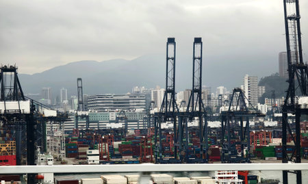 A container ship is docked in a harbor with a city behind itの写真素材