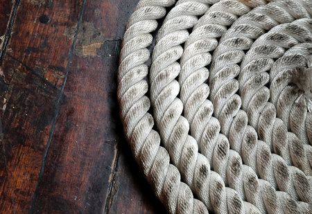 A sailor ropes is laying spread out on a wooden floor