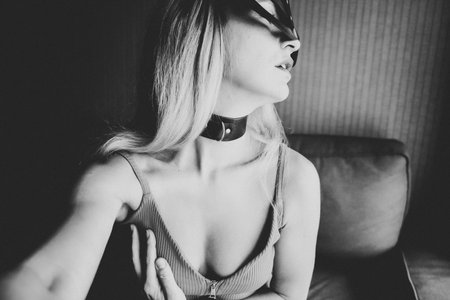 Young woman with black mask posing on the sofa