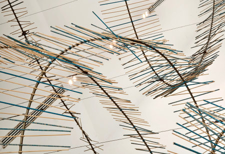 A closeup of a sculpture of sticks and wires hanging from the ceiling