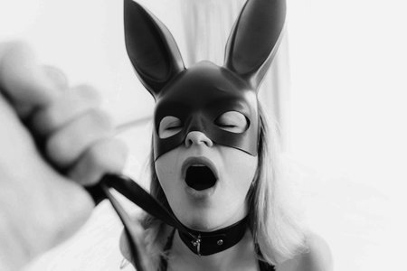 Young woman with black mask posing in the bedroomの写真素材